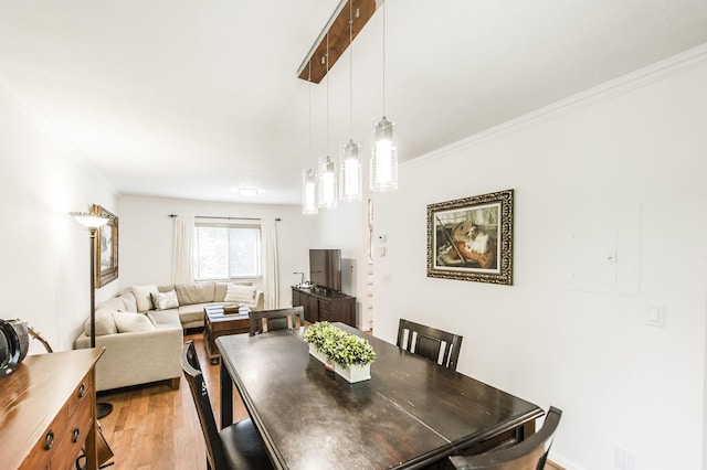 dining space featuring light wood-style floors and ornamental molding