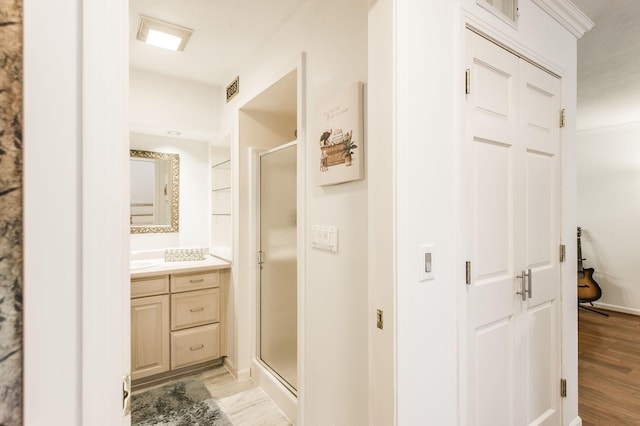 full bath featuring a stall shower, visible vents, wood finished floors, and vanity