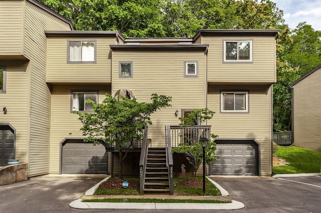 townhome / multi-family property with a garage, driveway, and stairway