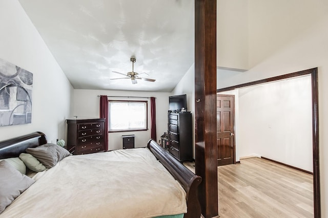 bedroom featuring lofted ceiling, light wood-style flooring, and a ceiling fan