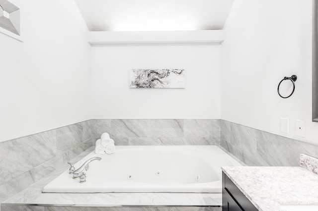 bathroom featuring a whirlpool tub, visible vents, and vanity