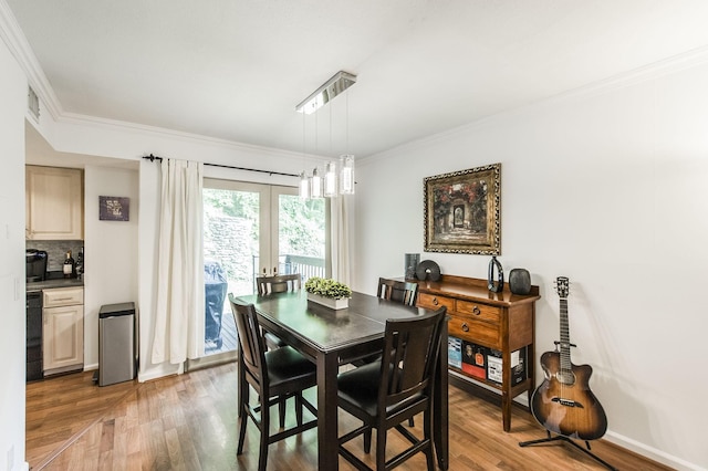 dining space with ornamental molding, baseboards, and wood finished floors