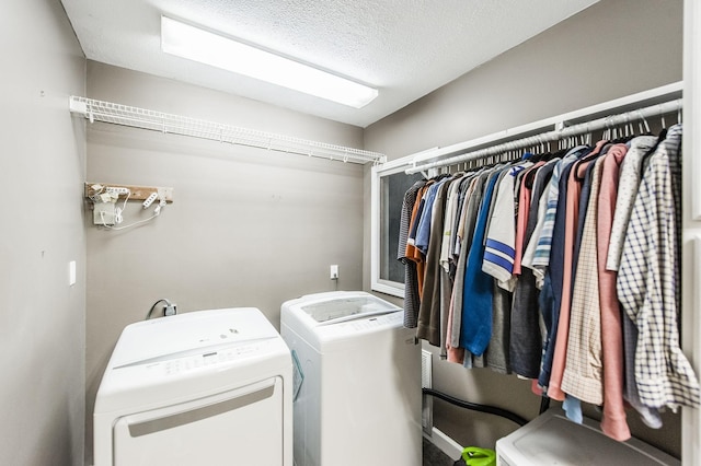 laundry area featuring washing machine and dryer, laundry area, and a textured ceiling