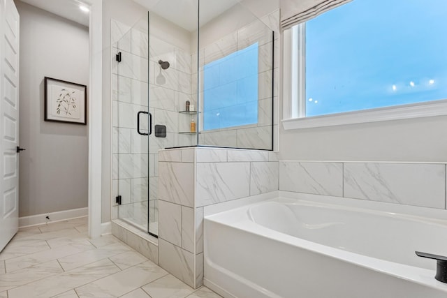 bathroom featuring marble finish floor, a shower stall, a bath, and baseboards