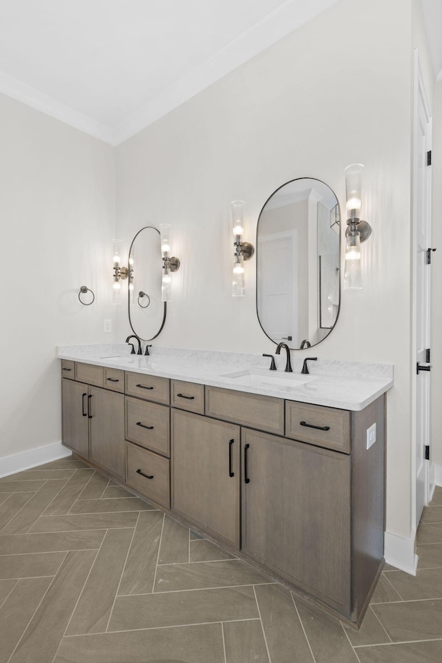 bathroom with double vanity, baseboards, ornamental molding, and a sink