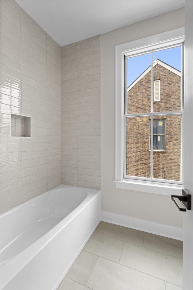 bathroom featuring a tub to relax in, baseboards, and tile patterned floors