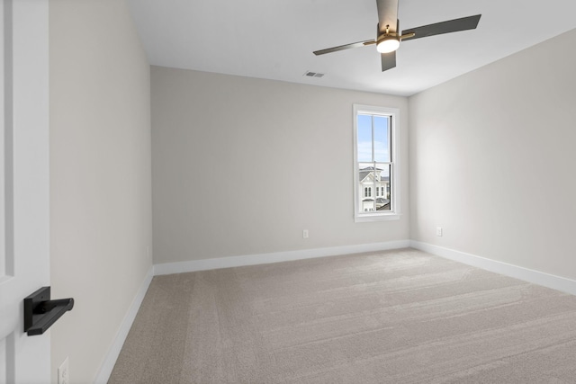 spare room featuring carpet floors, visible vents, baseboards, and a ceiling fan