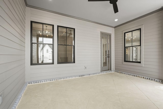 exterior space featuring wooden walls, a ceiling fan, and crown molding