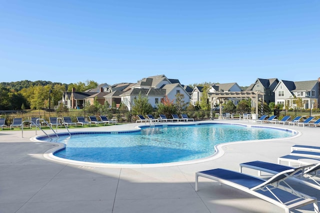 pool with a patio, fence, a residential view, and a pergola