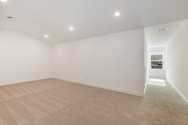 unfurnished room with light carpet, visible vents, baseboards, lofted ceiling, and recessed lighting