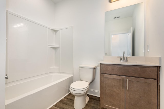 bathroom featuring shower / bath combination, toilet, vanity, wood finished floors, and baseboards