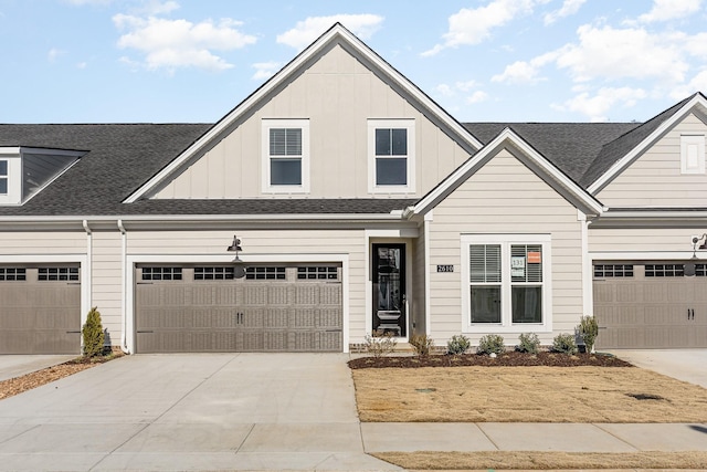 view of front of home with a garage, driveway, board and batten siding, and roof with shingles