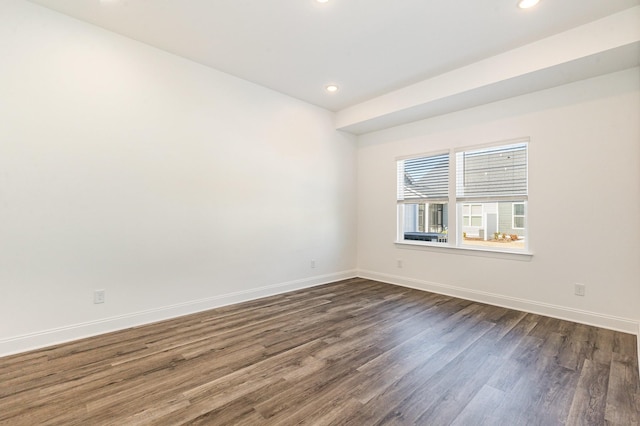 empty room with recessed lighting, dark wood finished floors, and baseboards