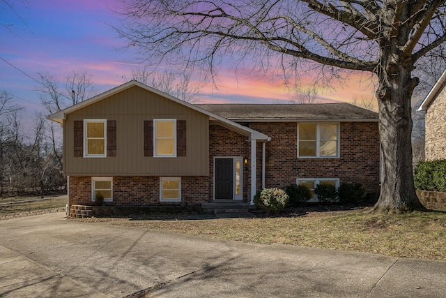 bi-level home featuring concrete driveway and brick siding