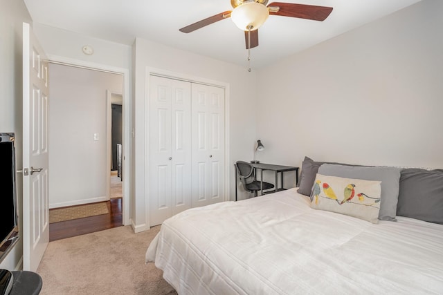 bedroom featuring baseboards, a ceiling fan, a closet, and light colored carpet