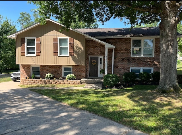 split foyer home featuring a front yard and brick siding