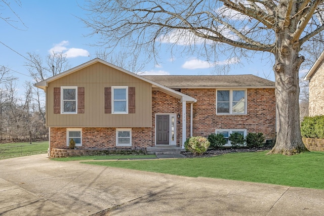 bi-level home with brick siding and a front yard