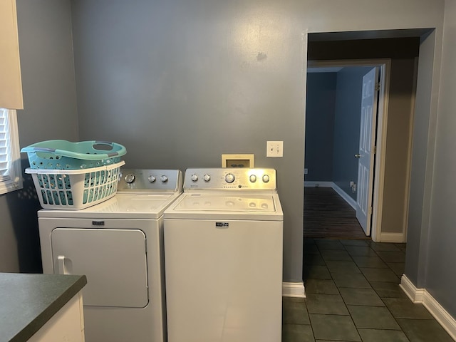 laundry area with laundry area, dark tile patterned floors, baseboards, and separate washer and dryer