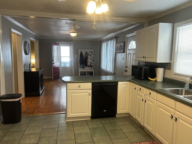 kitchen featuring a peninsula, white cabinetry, black appliances, dark countertops, and crown molding