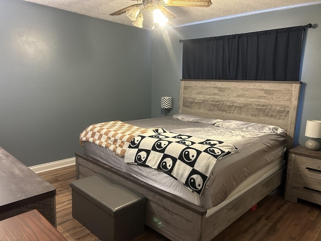 bedroom featuring a textured ceiling, dark wood-style flooring, a ceiling fan, and baseboards