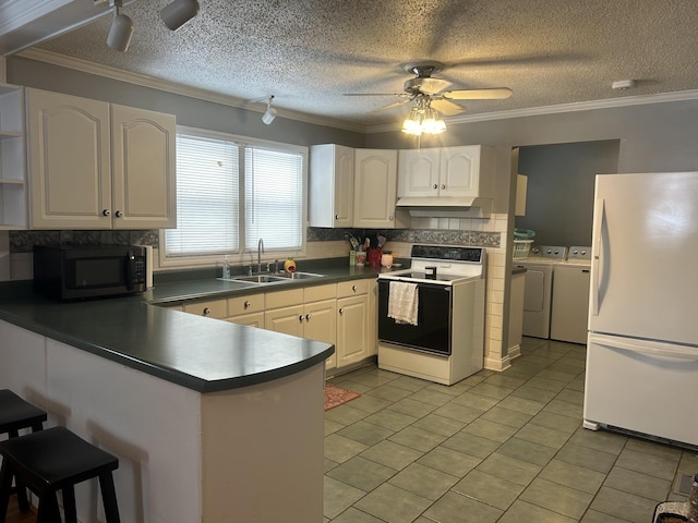 kitchen featuring electric stove, freestanding refrigerator, washer and dryer, black microwave, and a sink