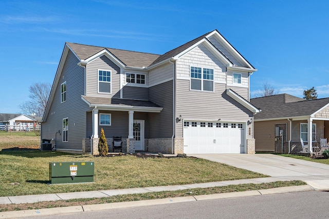 craftsman-style house featuring brick siding, concrete driveway, an attached garage, central AC unit, and a front yard