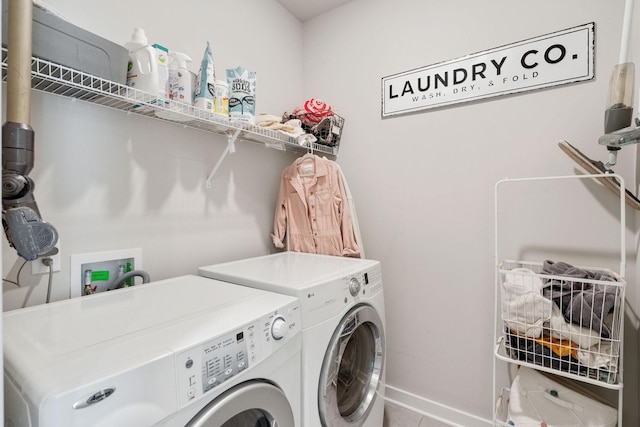 washroom featuring washer and dryer, laundry area, and baseboards