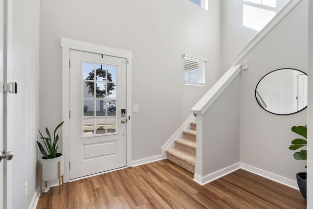 entrance foyer featuring stairway, baseboards, and wood finished floors