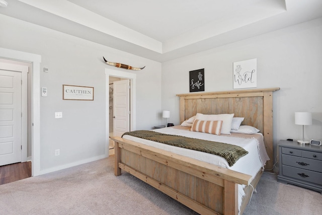 bedroom featuring baseboards, a raised ceiling, and carpet flooring