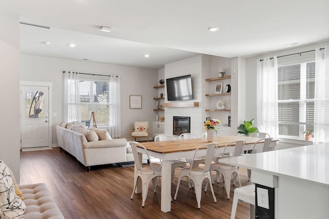 dining room featuring dark wood finished floors, a fireplace, and recessed lighting