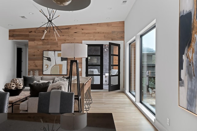 dining space with recessed lighting, visible vents, wood walls, and light wood-style flooring