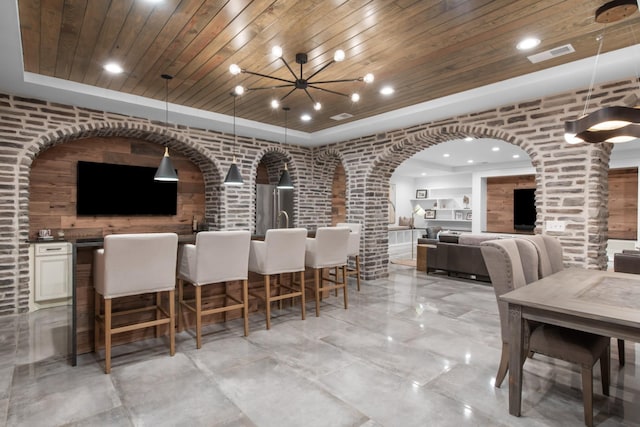 dining room with arched walkways, a dry bar, visible vents, wood ceiling, and brick wall