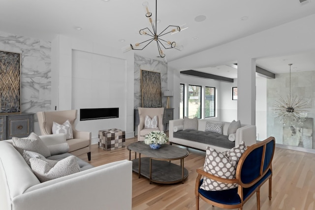 living room with visible vents, light wood-style flooring, a premium fireplace, an inviting chandelier, and tile walls