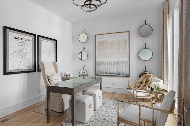 home office with light wood-type flooring, baseboards, and visible vents