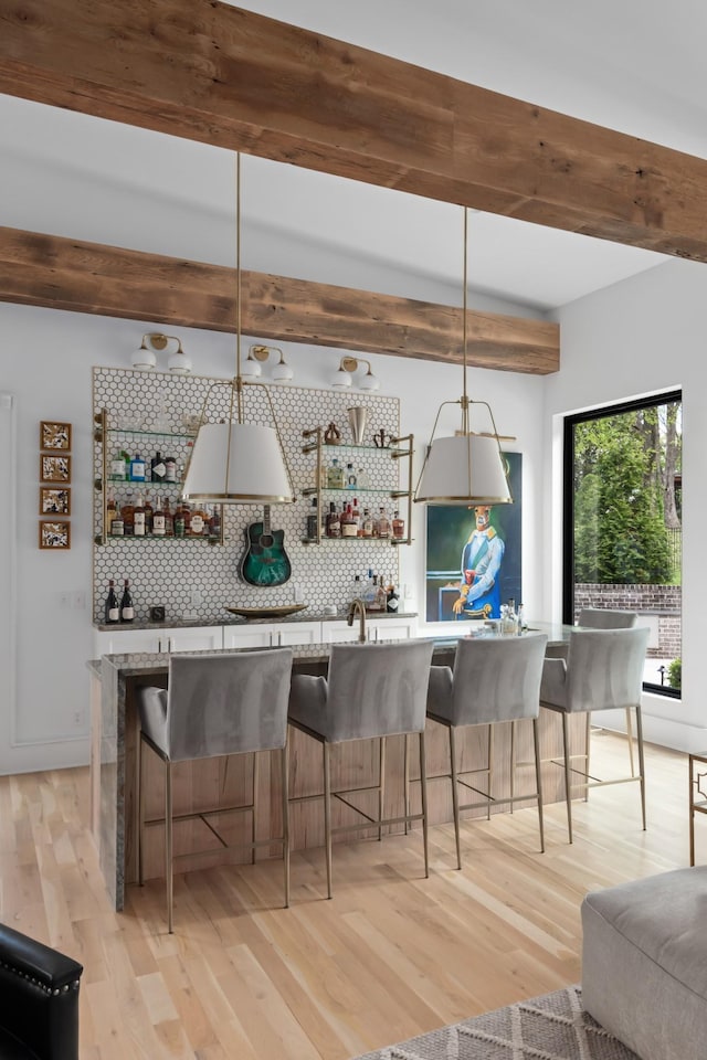 kitchen with tasteful backsplash, hanging light fixtures, a breakfast bar area, and open shelves