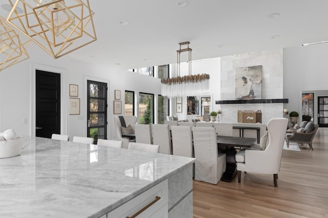 dining space featuring a high ceiling, light wood-type flooring, and recessed lighting