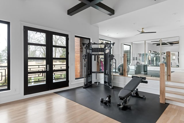 workout area with a ceiling fan, light wood-type flooring, and french doors