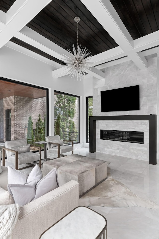 living room with marble finish floor, a fireplace, wood ceiling, a chandelier, and beamed ceiling