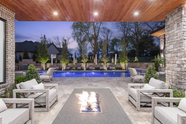 view of pool featuring a fenced in pool, fence, a patio, and an outdoor living space with a fire pit