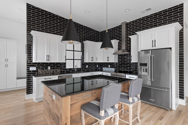 kitchen featuring appliances with stainless steel finishes, dark countertops, white cabinetry, and hanging light fixtures