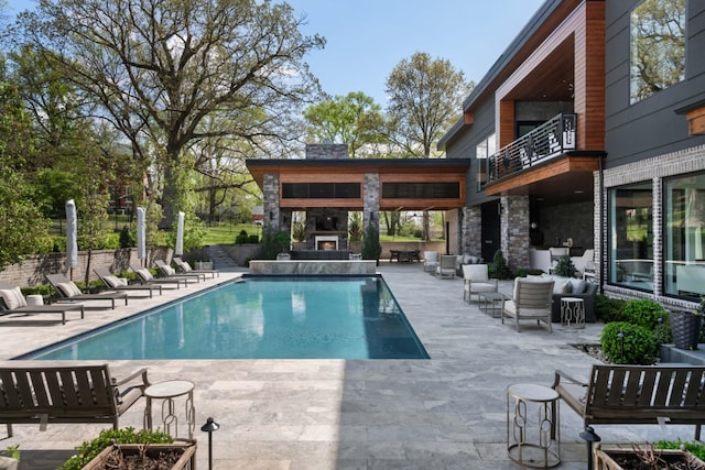 view of pool featuring a patio and a fireplace