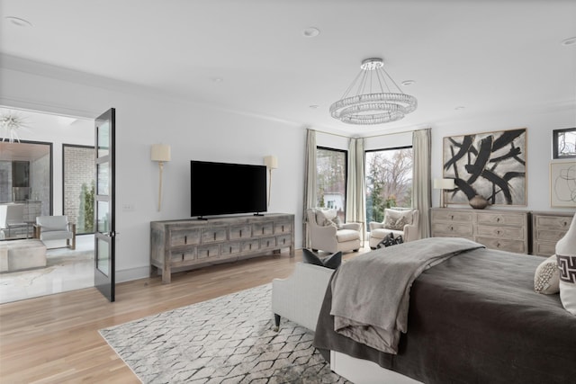 bedroom featuring light wood finished floors and an inviting chandelier