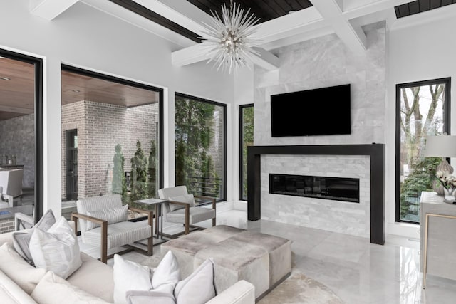 living area with beam ceiling, marble finish floor, a fireplace, an inviting chandelier, and coffered ceiling