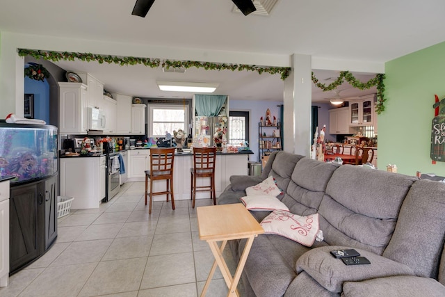 living area featuring light tile patterned floors and ceiling fan