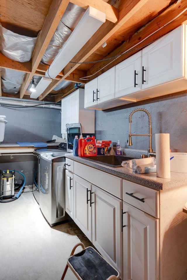 washroom featuring a sink, cabinet space, and washer and dryer