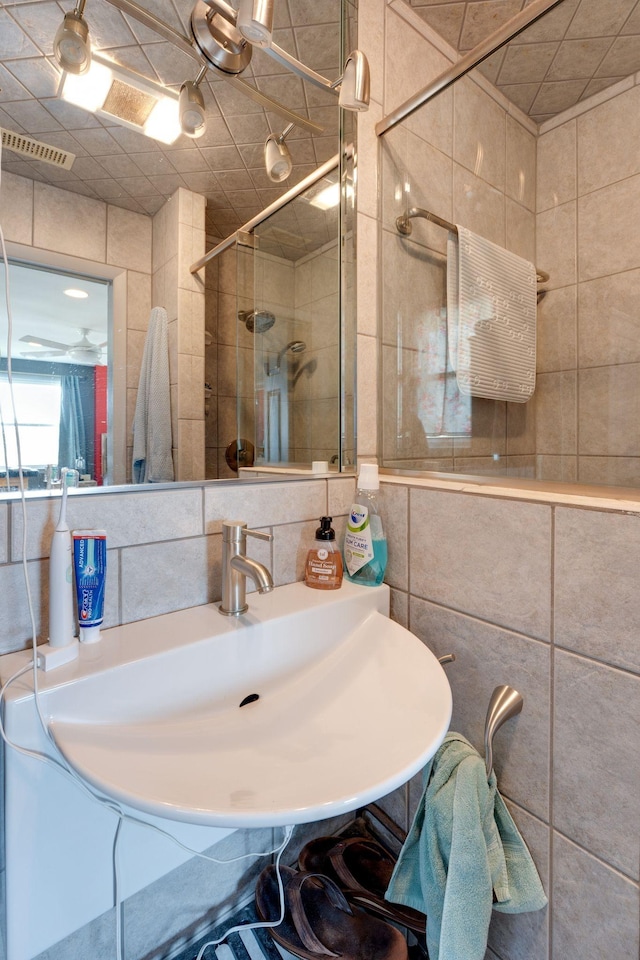 full bathroom with tasteful backsplash, a stall shower, visible vents, and tile walls