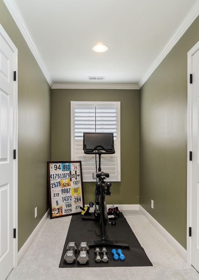 exercise area with baseboards, visible vents, ornamental molding, and light colored carpet