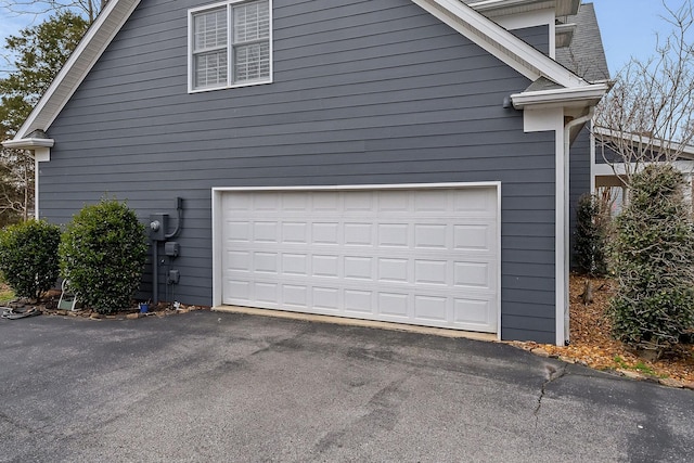 view of side of home with driveway and a garage