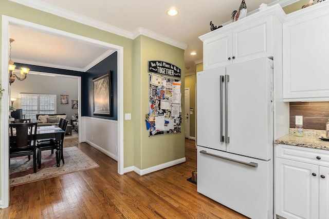 kitchen featuring an inviting chandelier, ornamental molding, freestanding refrigerator, dark wood-type flooring, and white cabinets