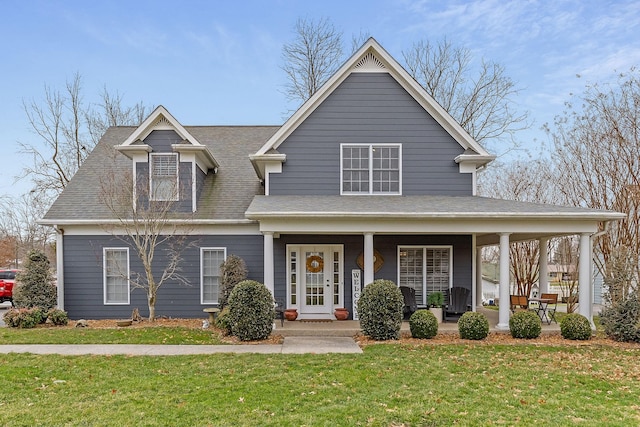 view of front of house with a porch, roof with shingles, and a front yard